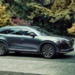 A gray 2021 Mazda CX-9 is shown from the side parked on a driveway.