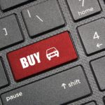 A red return key on a keyboard is shown thats says buy with a car icon.