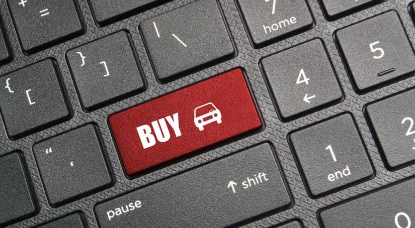 A red return key on a keyboard is shown thats says buy with a car icon.