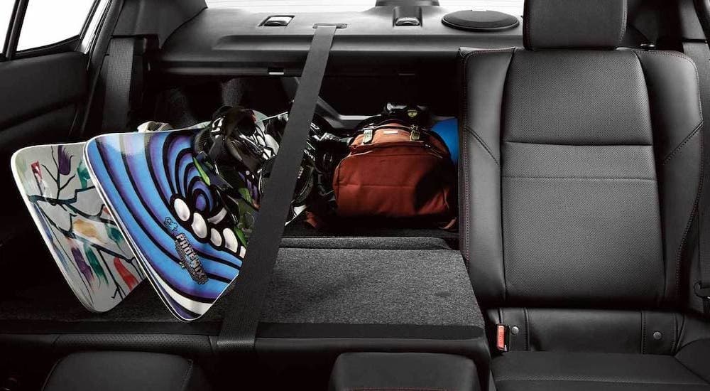 The black back seats and snowboarding equipment is shown in a 2021 Subaru WRX.