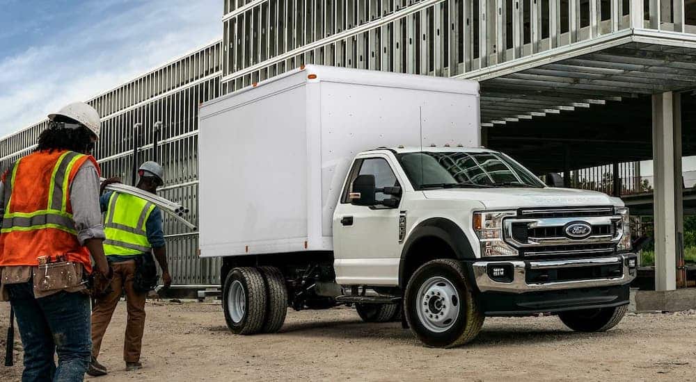 A white 2021 Ford Chassis Cab Box truck is parked at a construction site.