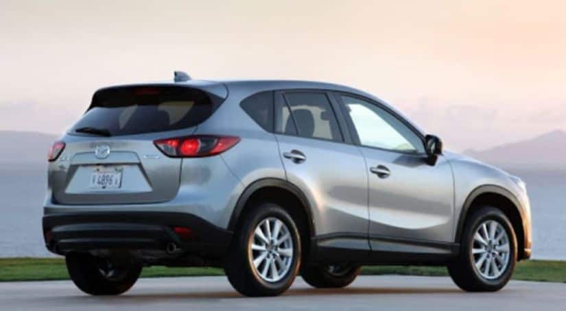 A silver 2015 Mazda CX-5 is shown from the rear at sunset.