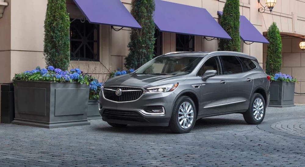 A light gray 2021 Buick Enclave is parked on cobblestones.