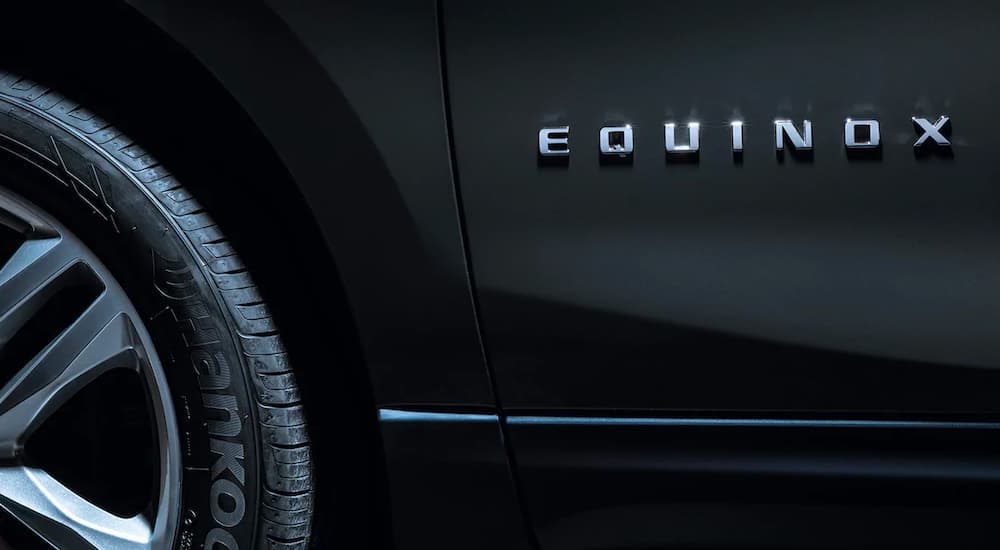 A close up shows the Equinox badge on a dark gray 2021 Chevy Equinox.