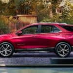 A red 2021 Chevy Equinox is shown from the side parked in a drive way.