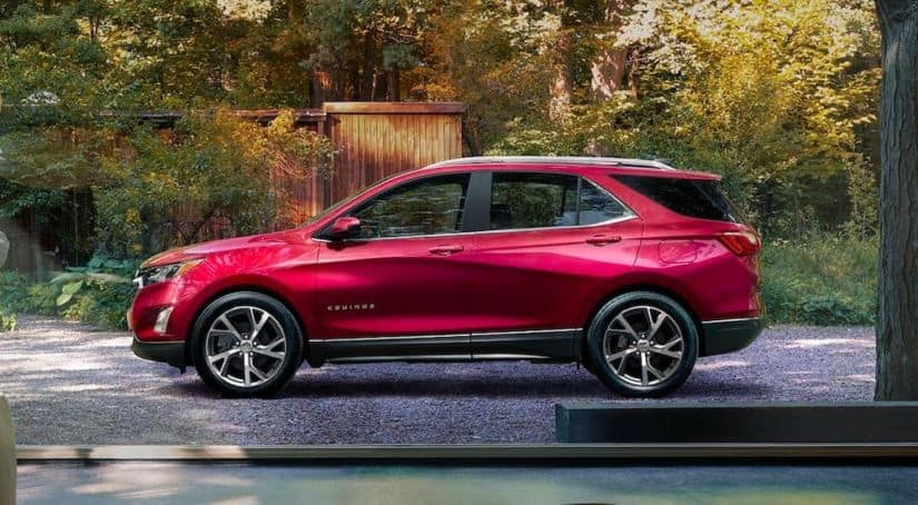 A red 2021 Chevy Equinox is shown from the side parked in a drive way.