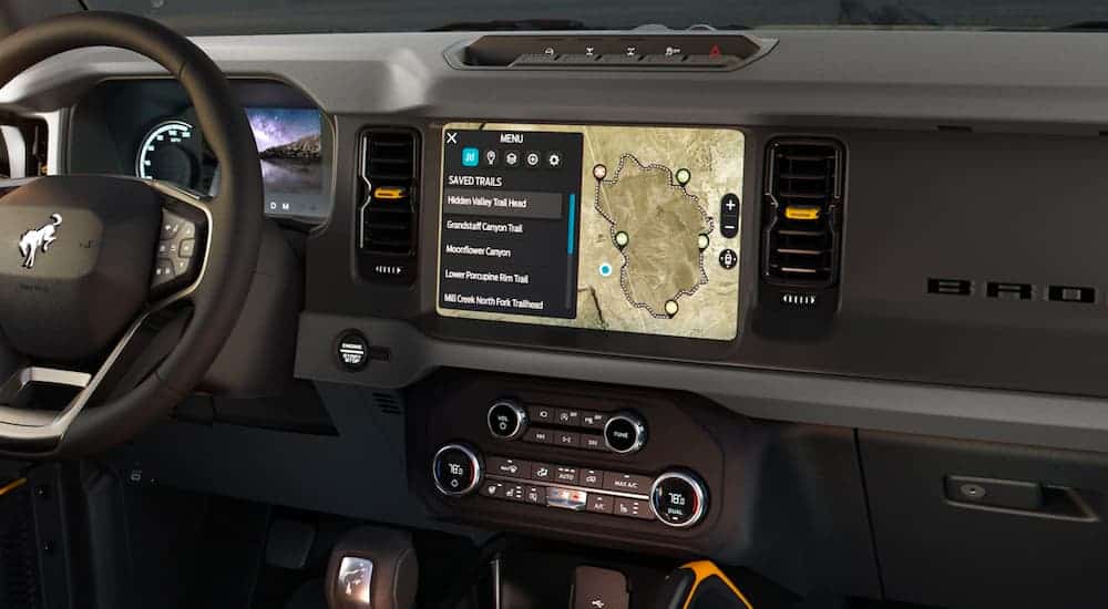 A close up shows the black interior and infotainment screen in a 2021 Ford Bronco Sport.