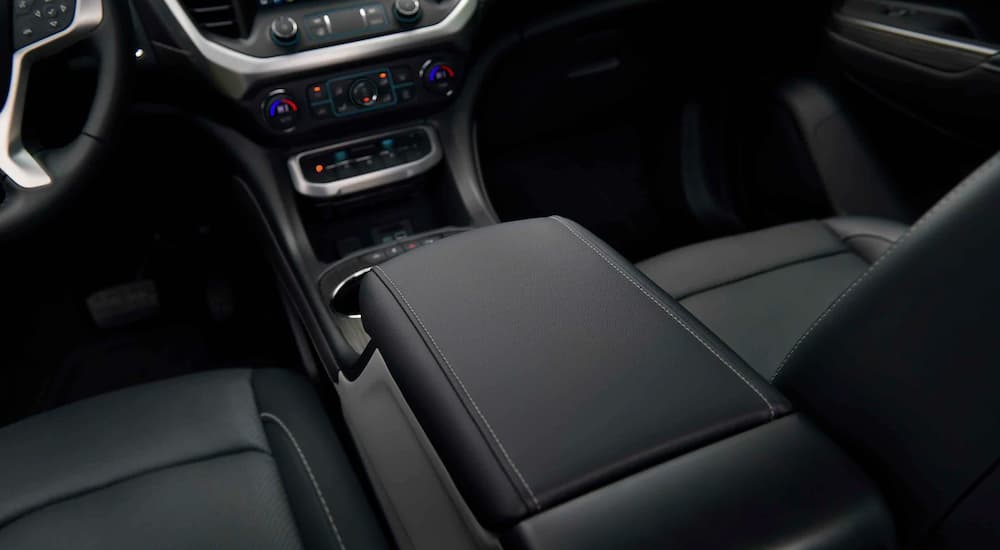 A close up shows the black interior and center console on a 2021 GMC Acadia SLE.