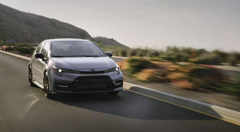 A gray 2021 Toyota Corolla is driving on a blurred highway.