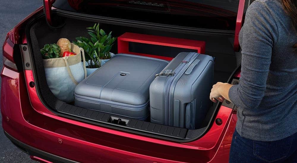 A close up shows the open trunk full of luggage in a red 2021 Nissan Versa.