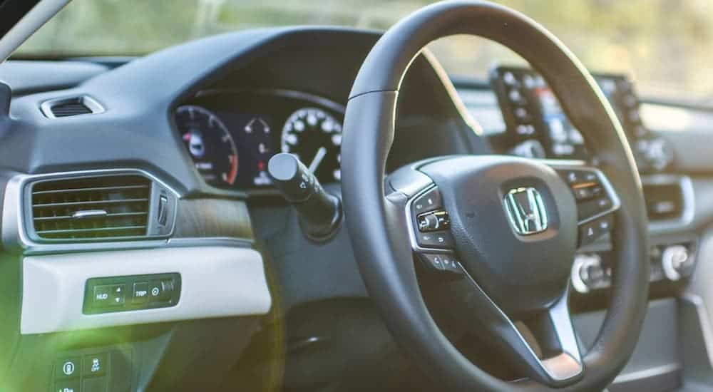 A close up shows the steering wheel and black interior in a 2021 Honda Accord.