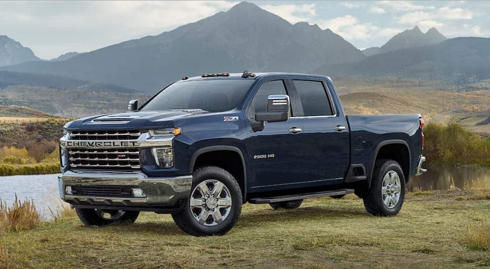 A blue 2021 Chevy Silverado 2500HD is shown from the side parked with mountains in the background, after leaving a Chevy dealer in Houston.