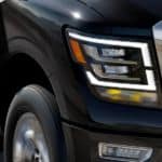 After leaving the Nissan Dealer, a black 2021 Nissan Titan is shown with a close up of the passenger headlight.