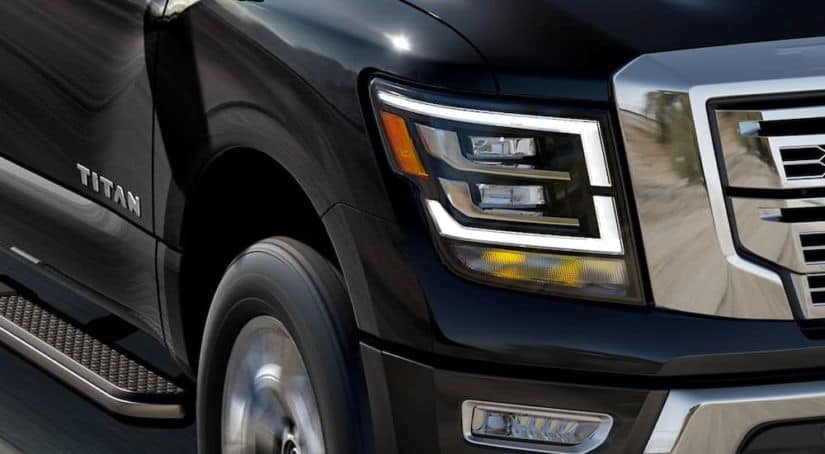 After leaving the Nissan Dealer, a black 2021 Nissan Titan is shown with a close up of the passenger headlight.
