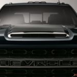 A closeup shows the silhouette on a black 2020 pre-owned Chevy 3500HD from the front against a gray background.