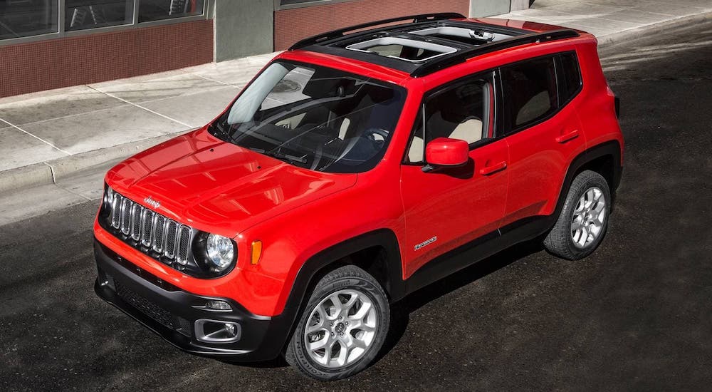A red 2018 Jeep Renegade is shown from a high angle on a city street after leaving a used Jeep dealer.