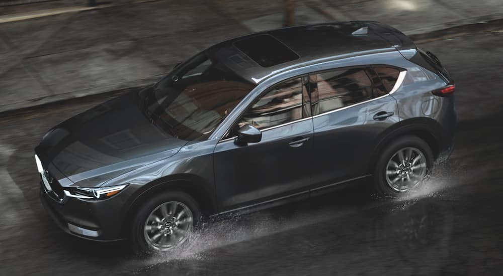 A drak grey 2021 Mazda CX 5 is shown from above driving in the rain.
