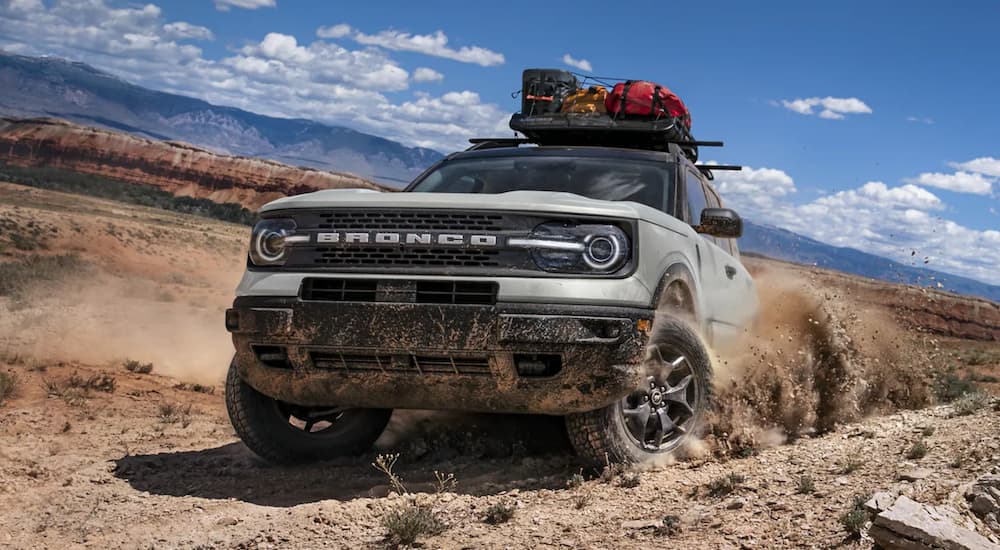 A silver 2021 Ford Bronco Sport powers through a desert as the tire tears up sand.