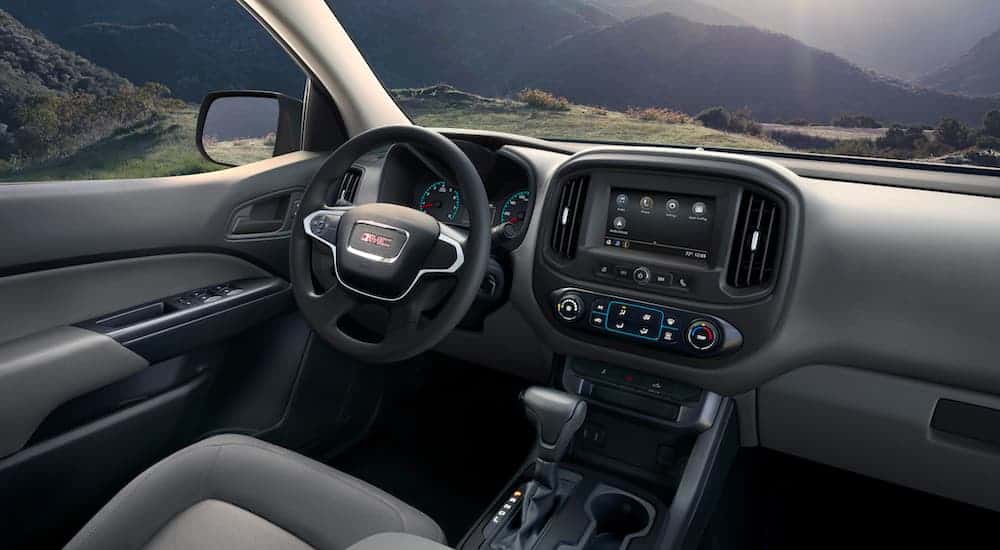 The gray and black interior shown in a 2021 GMC Canyon is over looking the mountains.