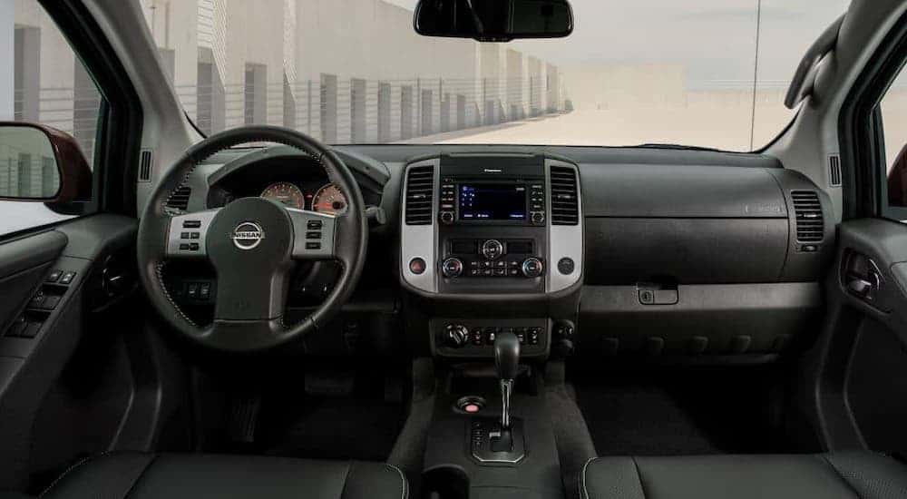 The black dashboard and interior of a 2021 Nissan Frontier is shown.