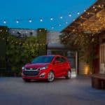 A red 2019 Chevy Spark is parked under decorative lights after leaving a certified pre-owned Chevrolet dealer.