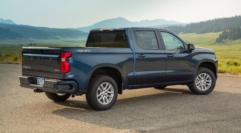 A blue 2020 Chevy Silverado RST is shown from a rear angle overlooking a valley.