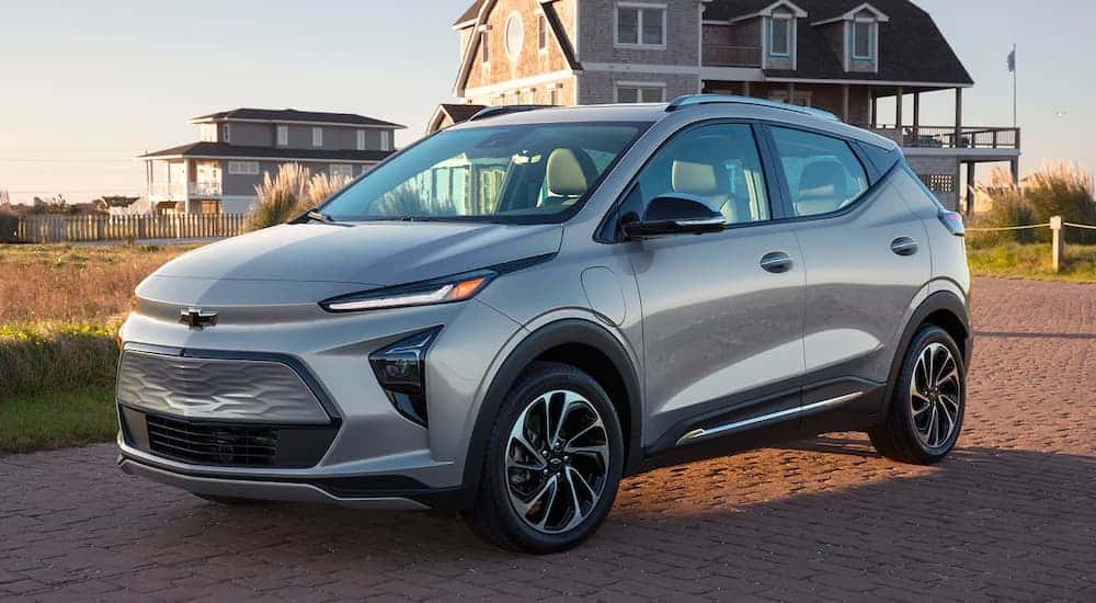 A silver 2022 Chevy Bolt EUV is shown from the side parked in front of a beach house.