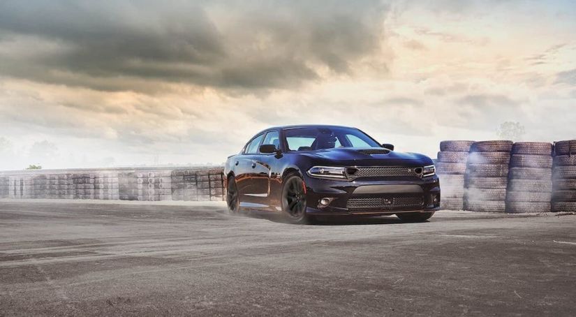A black 2021 Dodge Charger from a Dodge dealer is driving on a track.