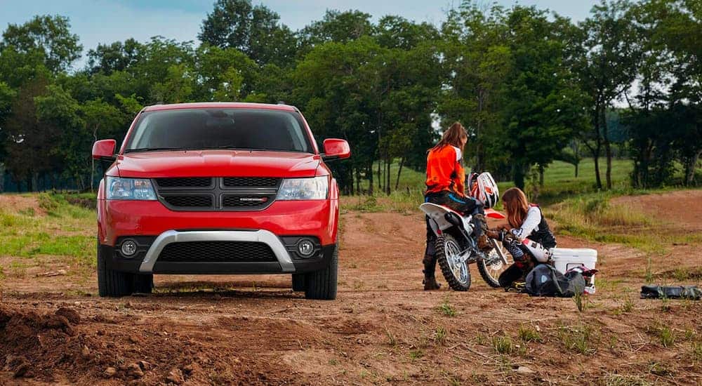 A red 2020 used Dodge Journey is shown parked on the dirt next to a dirtbike.