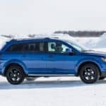 A blue 2020 used Dodge Journey is shown from the side driving through the snow.
