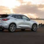 A silver 2021 Chevy Blazer is facing water at sunset.