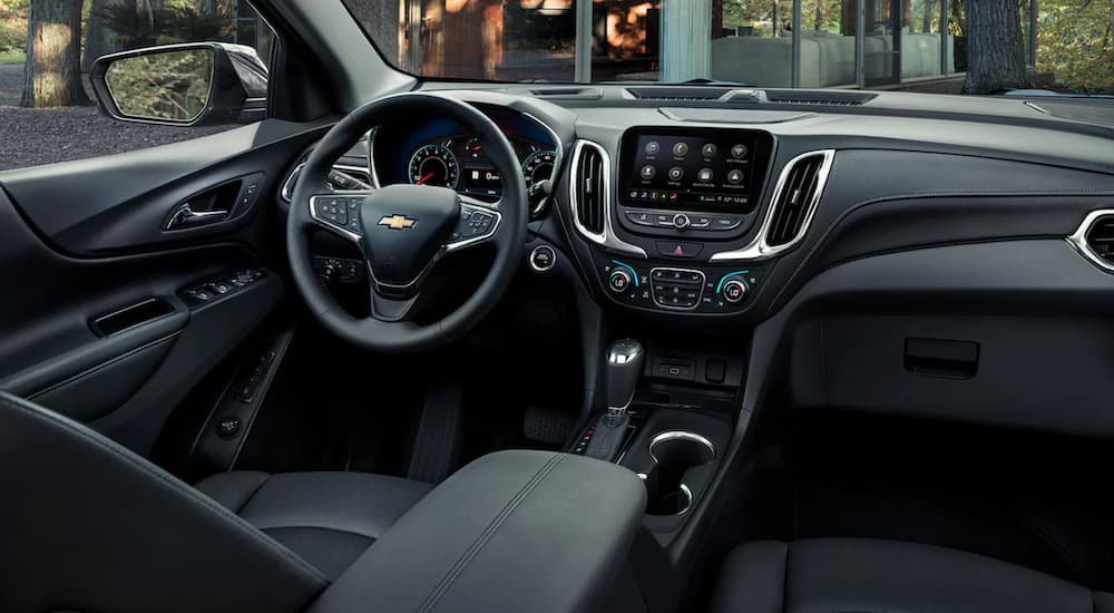 The interior of a 2021 Chevy Equinox shows the steering wheel and infotainment screen.
