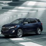 A dark blue 2021 Chevy Equinox is parked in a warehouse after winning a 2021 Chevy Equinox vs 2021 Nissan Rogue comparison.