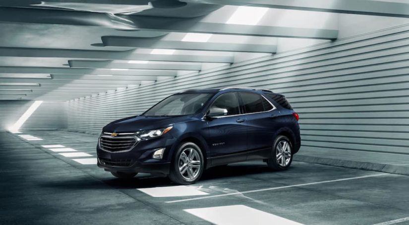 A dark blue 2021 Chevy Equinox is parked in a warehouse after winning a 2021 Chevy Equinox vs 2021 Nissan Rogue comparison.
