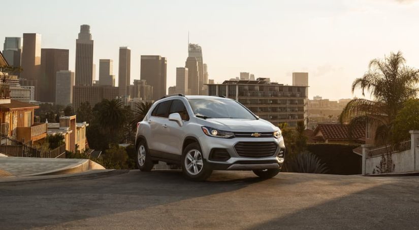 A white 2021 Chevy Trax is parked in a city after winning a 2021 Chevy Trax vs. 2021 Nissan Kicks comparison.
