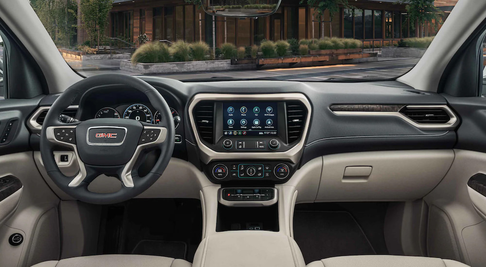 The interior of a 2021 GMC Acadia shows the steering wheel and infotainment screen. 