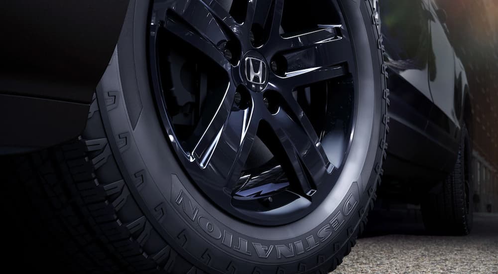 A close up shows the black wheel on a black 2021 Honda Ridgeline Black Edition.
