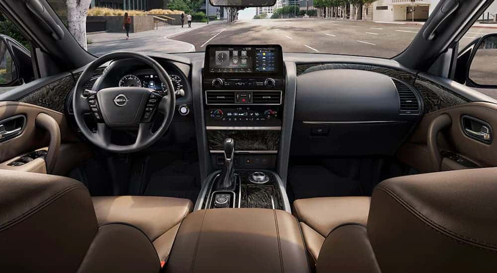 The tan and black front seats and dashboard are shown in a 2021 Nissan Armada SV.