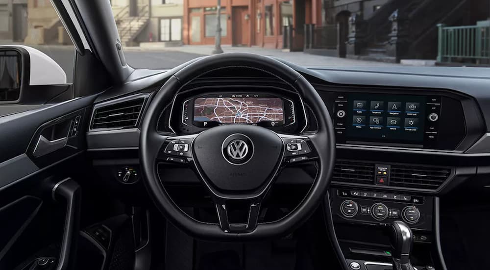 The interior of a 2021 Volkswagen Jetta shows the steering wheel and infotainment screen.