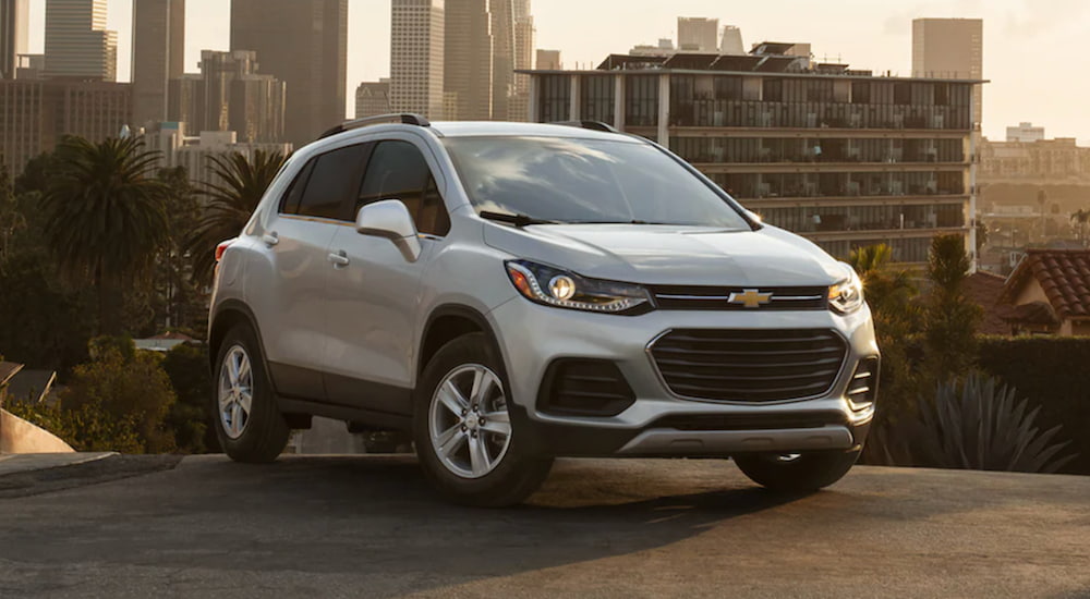A 2021 Chevy Trax is parked in a city as sunset.