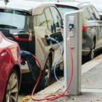 Multiple cars are parked at an electric charging station.