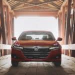 A popular used family car, a red 2021 Honda Accord, is parked on a covered wooden bridge.