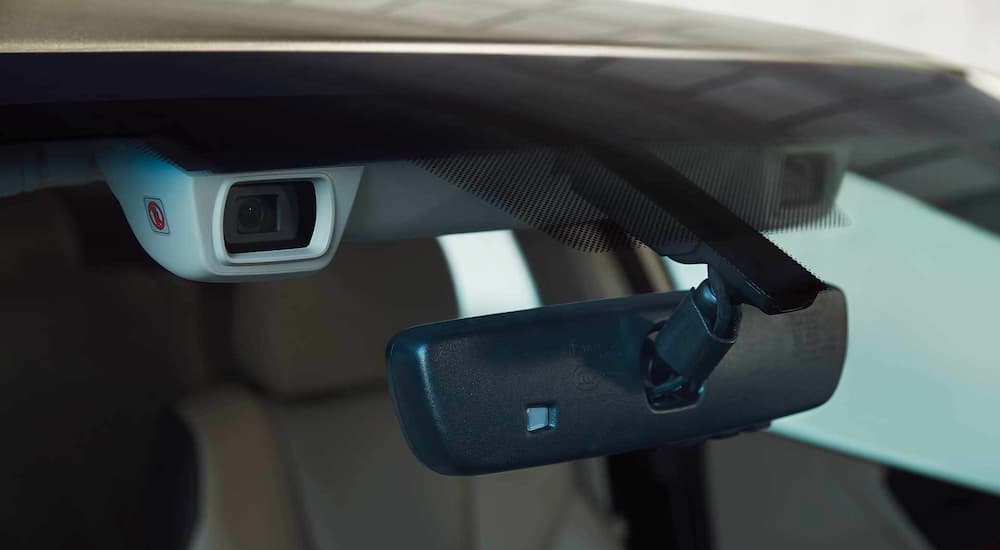 A close up shows the EyeSight camera next to the rear view mirror in a 2021 Subaru Legacy.