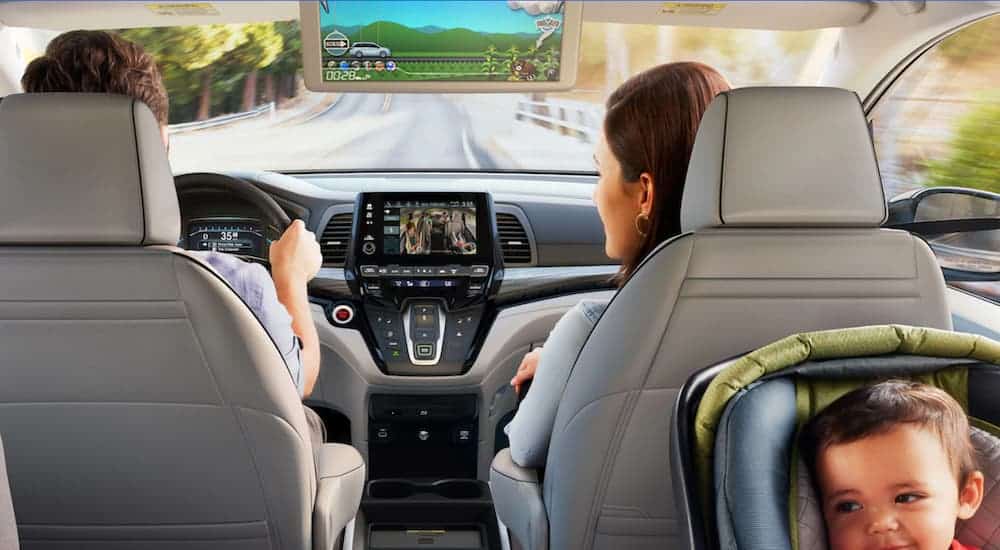 A family is shown driving down the road in a 2019 used Honda Odyssey.