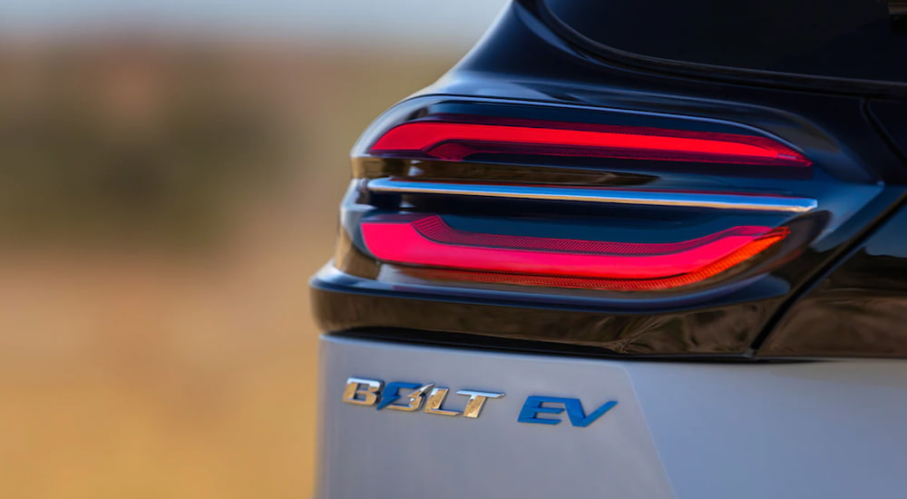The emblem of a light blue 2022 Chevy Bolt EV is shown under the brake light.