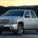 A silver 2012 Chevy Silverado LTZ is parked in front of a mountain at sunset after leaving a used Chevy Silverado 1500 dealer.
