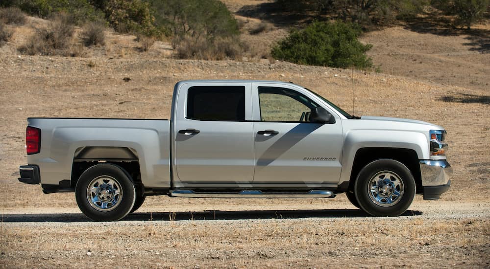 A silver 2017 Chevy Silverado is shown parked in a field after leaving a used Chevy Silverado 1500 dealer.