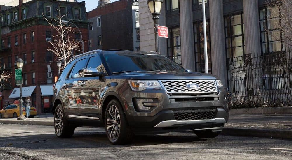 A 2016 Ford Explorer is shown from the front driving down a city street.
