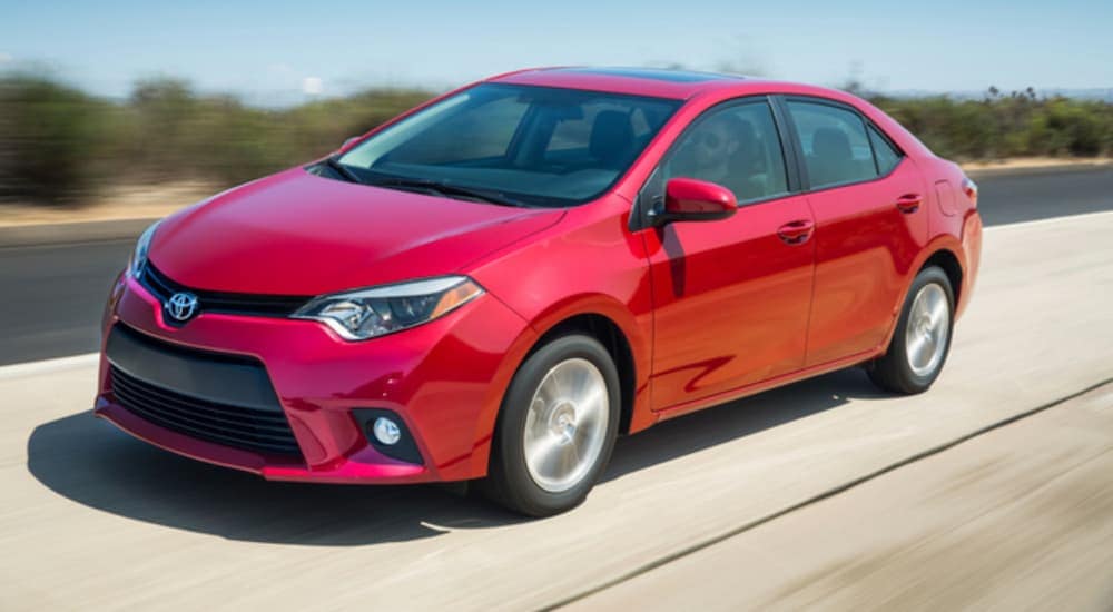 A red 2016 Toyota Corolla is being driving down an open road.