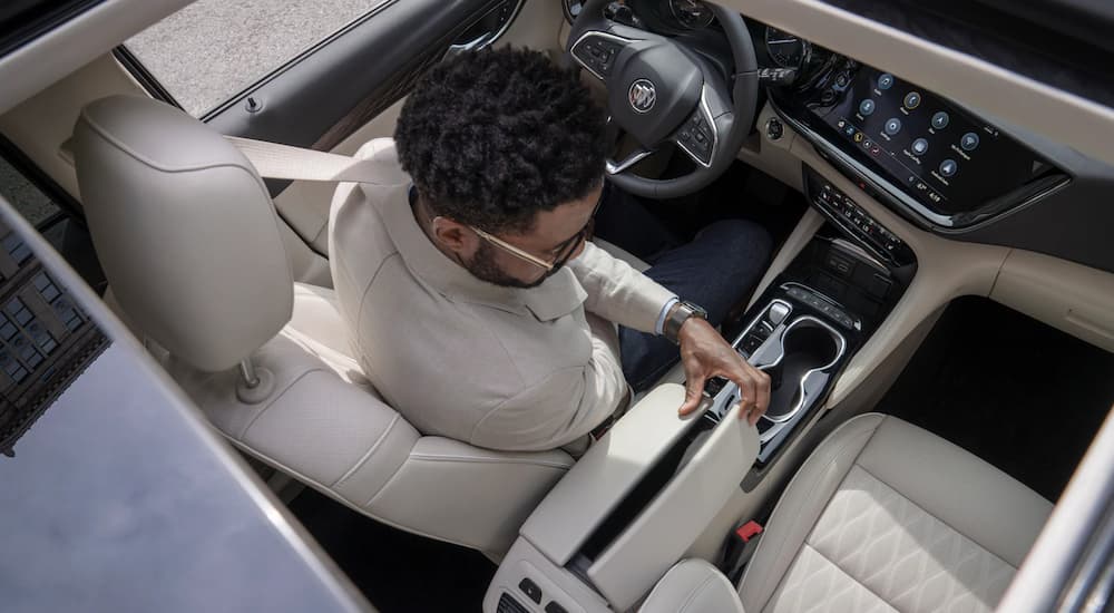 A driver in the white interior of a 2021 Buick Envision is shown from above.